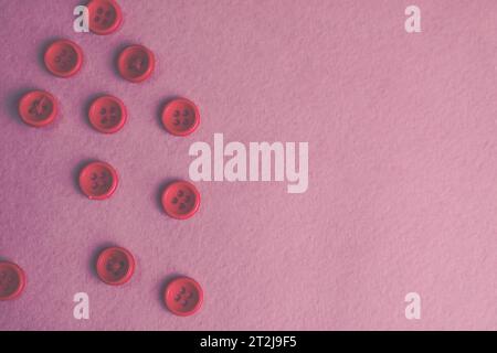 Beautiful texture with many round pink buttons for sewing, needlework. Copy space. Flat lay. Pink, purple background. Stock Photo