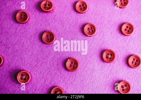 Beautiful texture with many round pink buttons for sewing, needlework. Copy space. Flat lay. Pink, purple background. Stock Photo