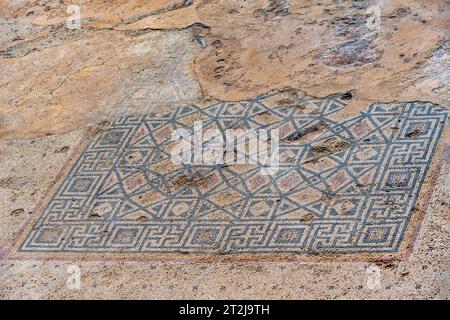 Ancient, antique mosaic of small colored tiles with geometric pattern, remains of Roman pavement on a pool floor at Caesarea, Israel. Stock Photo
