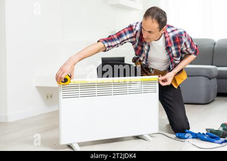 Handyman fix the radiator in the room Stock Photo