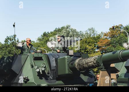 16.08.2023 Warsaw, Poland. Military parade with real-life soldiers. Outdoor shot of two relaxed soldiers in sunglasses sitting on modern military tank. High quality photo Stock Photo