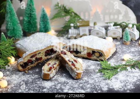 Sliced Chrismas stollen with powdered sugar and christmas decoration Stock Photo