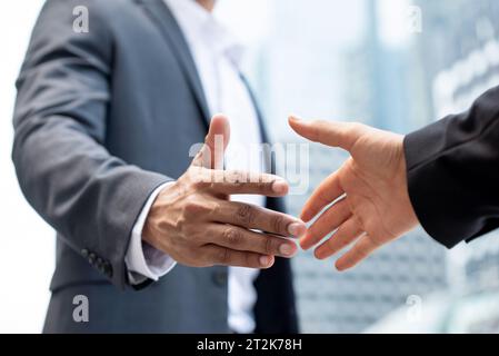 Businessmen making handshake outdoors in city office building background for merger and acquisition concept Stock Photo
