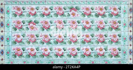 Rows of antique Nyonya Tiles with pink flowers with green background. Vintage Baba and Nyonya style floral tile pattern in penang. Traditional Peranak Stock Photo