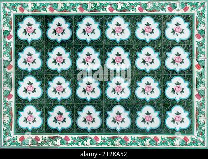 Rows of antique Nyonya Tiles with pink roses with green background. Vintage wall tile in penang. Stock Photo