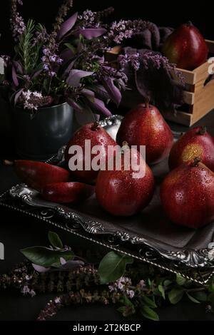 Red pears Red Bartlett sort in a low key on the black background. Dark photo with the pears. Stock Photo