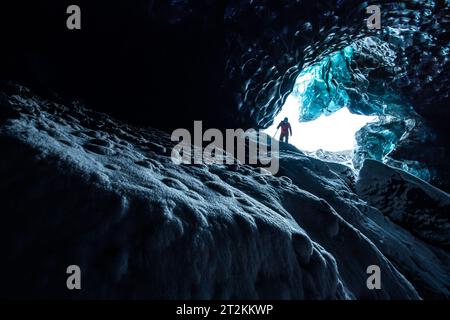 Adventurer discovering the inside of an ice cave in Iceland Stock Photo