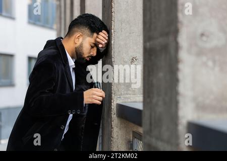 Unhappy sad Indian business man frustrated stress pensive feeling bad after company lost job unemployment problem financial crisis. Arabian Hindu freelancer guy stay at office business center building Stock Photo