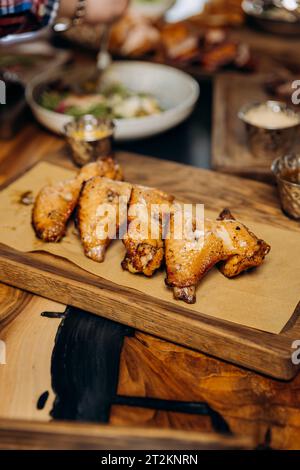 Buffalo barbecue chicken wings with sauce and beer on board. Fast food concept. Beer appetizer Stock Photo