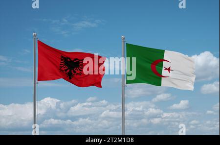 Albania and Algeria flags waving together in the wind on blue cloudy sky Stock Photo