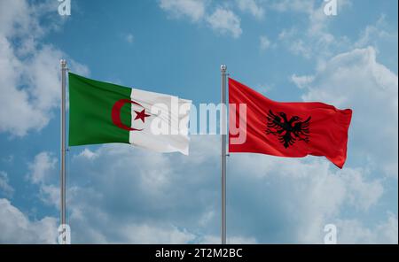 Algeria and Albania flags waving together in the wind on blue cloudy sky Stock Photo