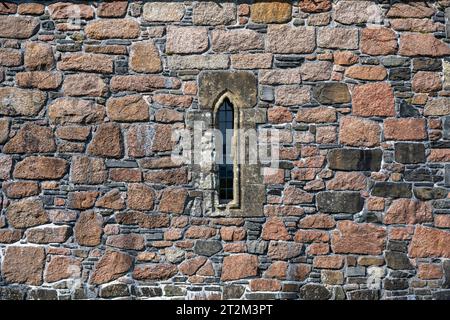 Ross of Mull granite and basalt house wall with a narrow window, full size, background Stock Photo