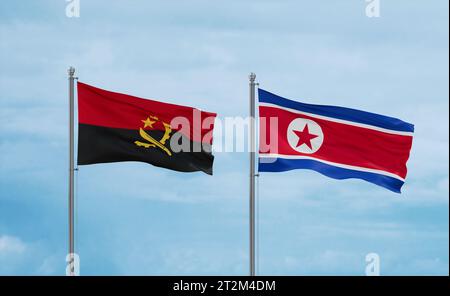 North Korea and Angola flags waving together in the wind on blue cloudy sky Stock Photo