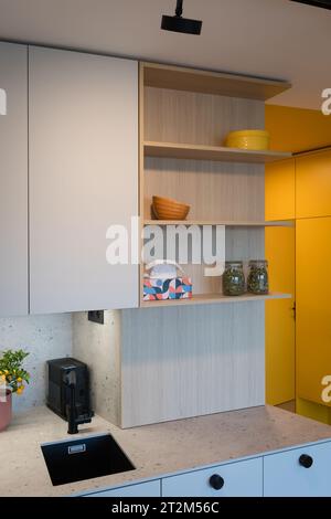Custom kitchen cabinet with hidden circuit breaker box in small urban apartment Stock Photo