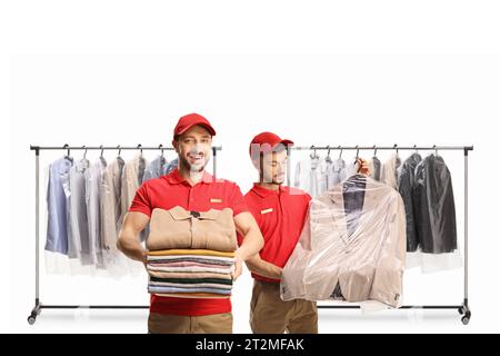 Dry cleaning workers with a pile of folded clothes and a suit on a hanger isolated on a white background Stock Photo