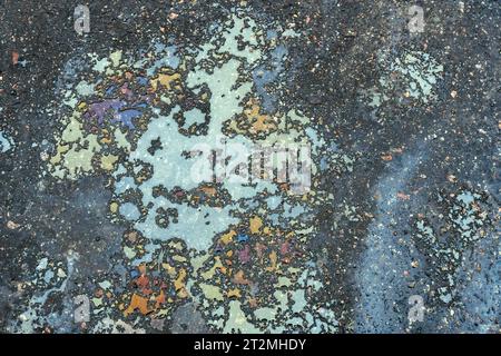 Colored oil stains close-up, color of a gasoline stain on asphalt as a texture or background. Stock Photo