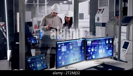 Factory Engineers In Helmets. Checking Industrial Facility Stock Photo