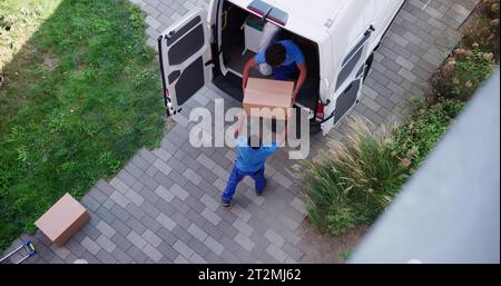 High Angle View Of Delivery Men Unloading The Cardboard Boxes From Truck Stock Photo