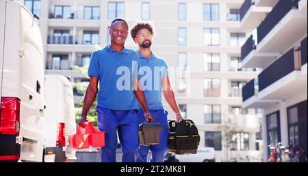 Confident Technicians Walking New Truck On Street Stock Photo