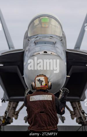 San Diego, United States. 18th Oct, 2023. U.S. Navy Aviation Structural Mechanic 3rd Class Angel Garciacastill, directs a F/A-18F Super Hornet fighter aircraft, with the Black Aces of Strike Fighter Squadron 41 for positioning on the flight deck of the Nimitz-class aircraft carrier USS Abraham Lincoln operating on the Pacific Ocean, October 18, 2023 off the coast of San Diego, California. Credit: MC2 Clayton Wren/U.S. Navy/Alamy Live News Stock Photo