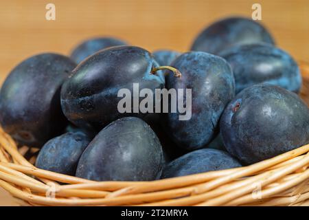 Ripe house plums in basket Stock Photo