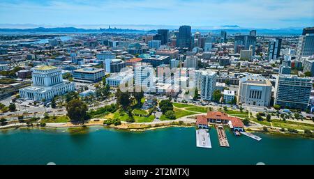 Aerial with restaurant and downtown Oakland courthouse with distant San Francisco skyscrapers Stock Photo