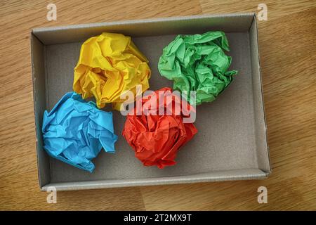 Colorful crumpled paper balls in a cardboard box. Idea Concept. Close up. Stock Photo