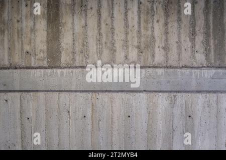 Textured grey concrete wall with imprints from the wood boards used during its pouring. Stock Photo