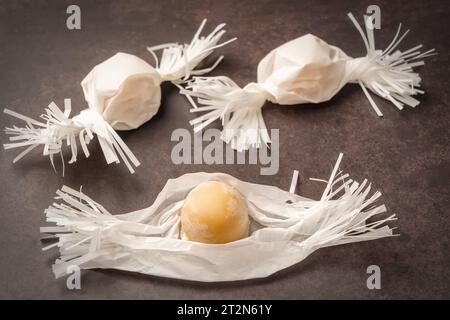 Portuguese marzipan delicacy candy lollipops in a wrapper. Gourmet sweets from the Algarve Portugal on a marble background close-up. Stock Photo