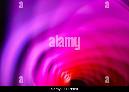 Dark and creepy infinity loop of red and purple with black hole in abstract background art Stock Photo