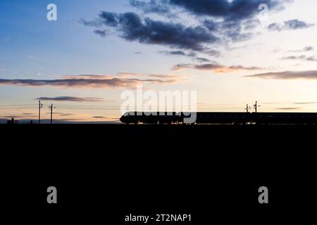 The Locomotive Services Blue Pullman luxury dining train on the west coast mainline making a sunset silhouette  it is a converted Intercity 125. Stock Photo