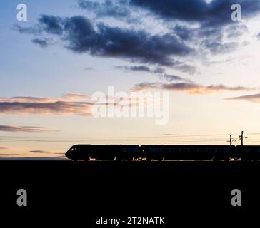 The Locomotive Services Blue Pullman luxury dining train on the west coast mainline making a sunset silhouette  it is a converted Intercity 125. Stock Photo