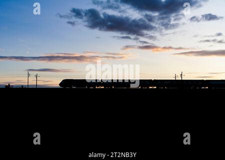 The Locomotive Services Blue Pullman luxury dining train on the west coast mainline making a sunset silhouette  it is a converted Intercity 125. Stock Photo