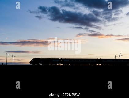 The Locomotive Services Blue Pullman luxury dining train on the west coast mainline making a sunset silhouette  it is a converted Intercity 125. Stock Photo