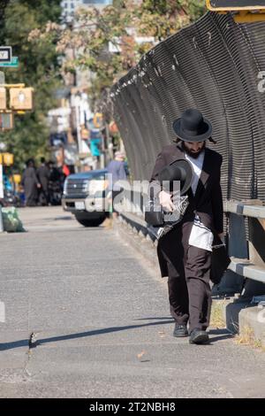 On a windy day, an orthodox Jewish man wlks over the BQE overpass on Lee avenue in his was home from morning prayers. In Williamsburg, Brooklyn, N. Stock Photo