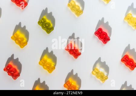 Gelatin sweet bright candies in the form of bears, laid out diagonally on a white background. Background for cards, invitations to children's parties. Stock Photo
