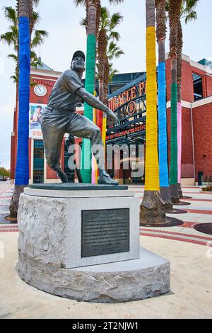 Willie Mays statue with colorful palm trees behind it with Oracle Park entrance Stock Photo