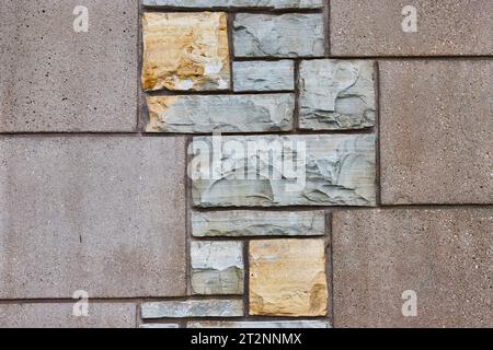 Vertical concrete wall with textured silver and gold stones in asymmetrical pattern background Stock Photo