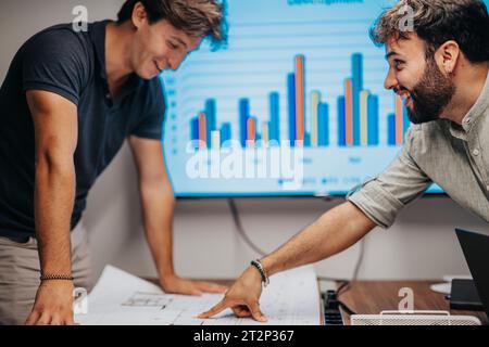 Successful Multiracial Business Team Collaborating on Architectural Blueprints in the Conference Room Stock Photo