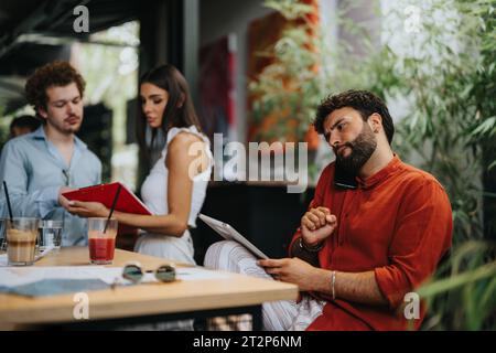 Business professionals collaborating outdoors, discussing blueprint and project development. Creative teamwork for real estate and urban planning. Stock Photo