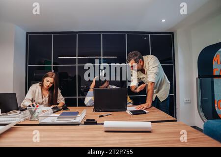 Multiracial colleagues in a modern boardroom collaborate on a new project, aiming for innovation and growth through teamwork and strategic planning. Stock Photo