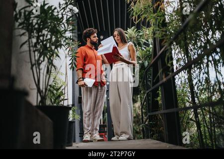 Collaborative Architects Discussing Blueprint at Construction Site Stock Photo