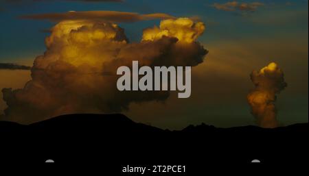 Towering storm clouds develop into a menacing monsoon event over an Arizona desert mountain range at sunset. Stock Photo