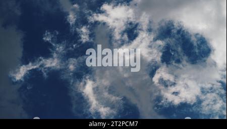 Wispy and dreamy white clouds in a deep blue sky. Stock Photo