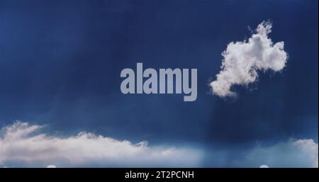 Dreamy fractus cloud (scud cloud), brilliant white against a blue summer sky. Stock Photo