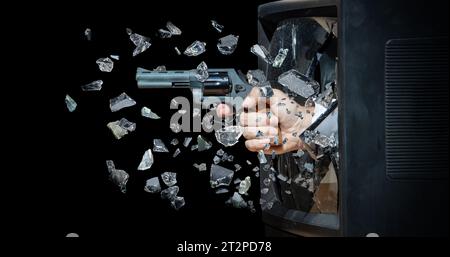 A hand with a gun smashes the CRT screen from inside the television Stock Photo