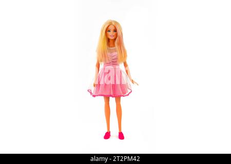 October 9, 2023. Barnaul, Russia: Barbie doll with loose blond hair in a pink dress standing isolated on a white background. Stock Photo