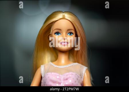 October 9, 2023. Barnaul, Russia: Portrait of a Barbie doll with loose blond hair in a pink dress on a dark background. Stock Photo