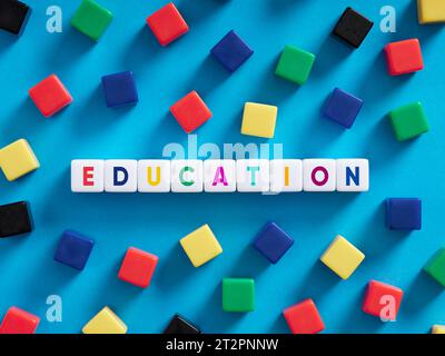 Education, training, teaching and learning concept. Colorful cubes on blue background with the word education. Stock Photo