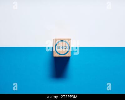 The word Ethics on wooden cubes on blue and white background. Business ethics, ethical corporate culture, business integrity and moral principles conc Stock Photo